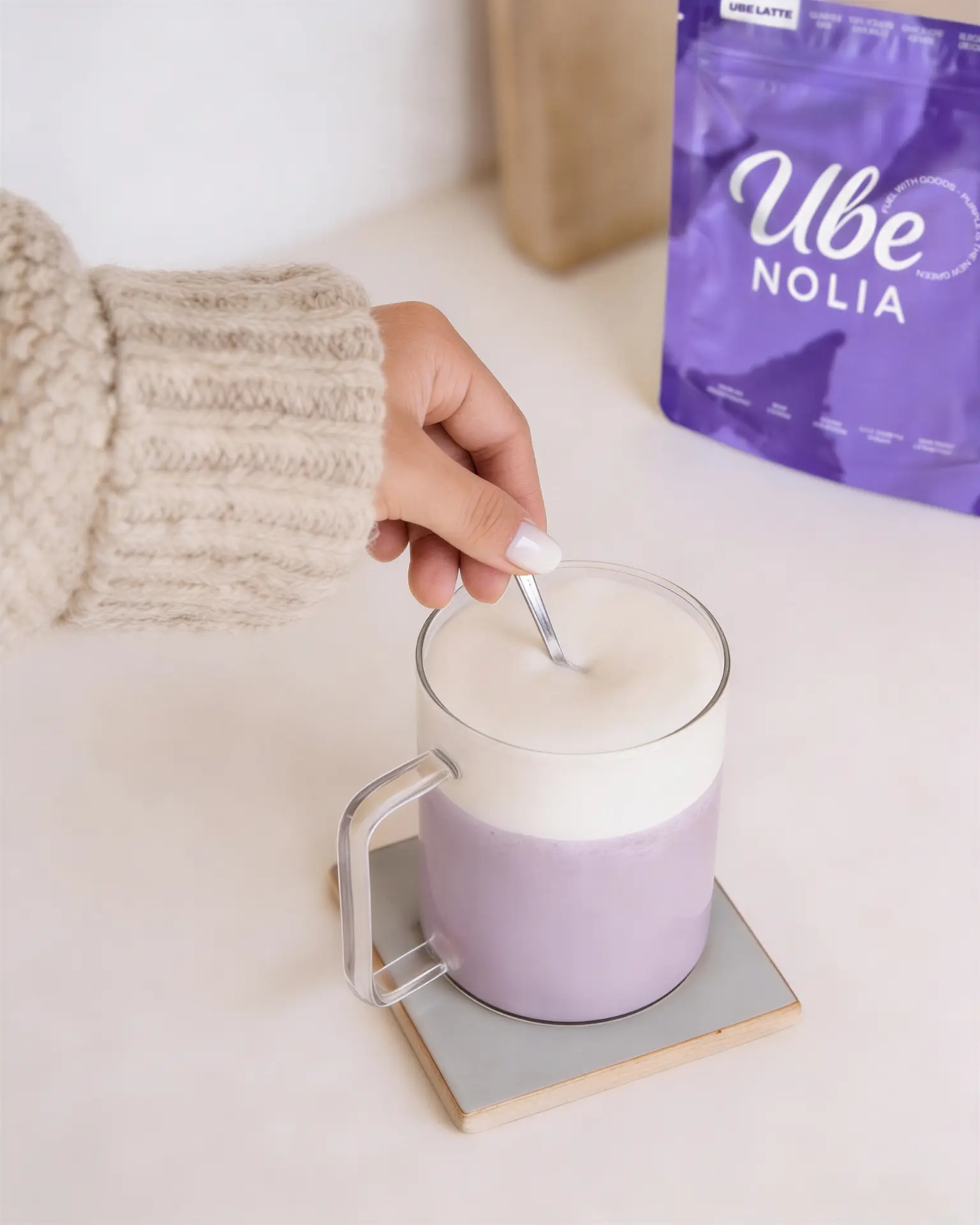 Ube Nolia Ube Latte wird neben dem Ube Pulver Beutel umgerührt