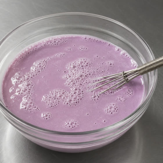 Violette Ube-Milchmischung in einer Glasschüssel verquirlt | Ube Nolia