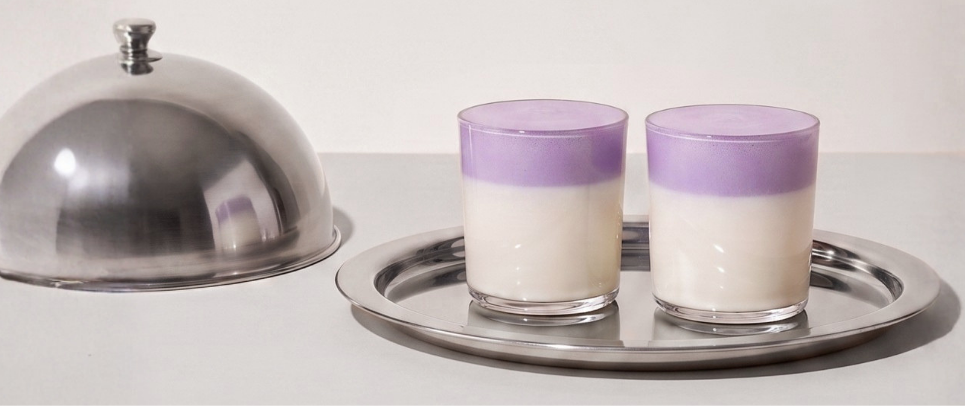 Einladung zum Ube Nolia Treueprogramm mit Ube Lattes auf einem Silbertablett