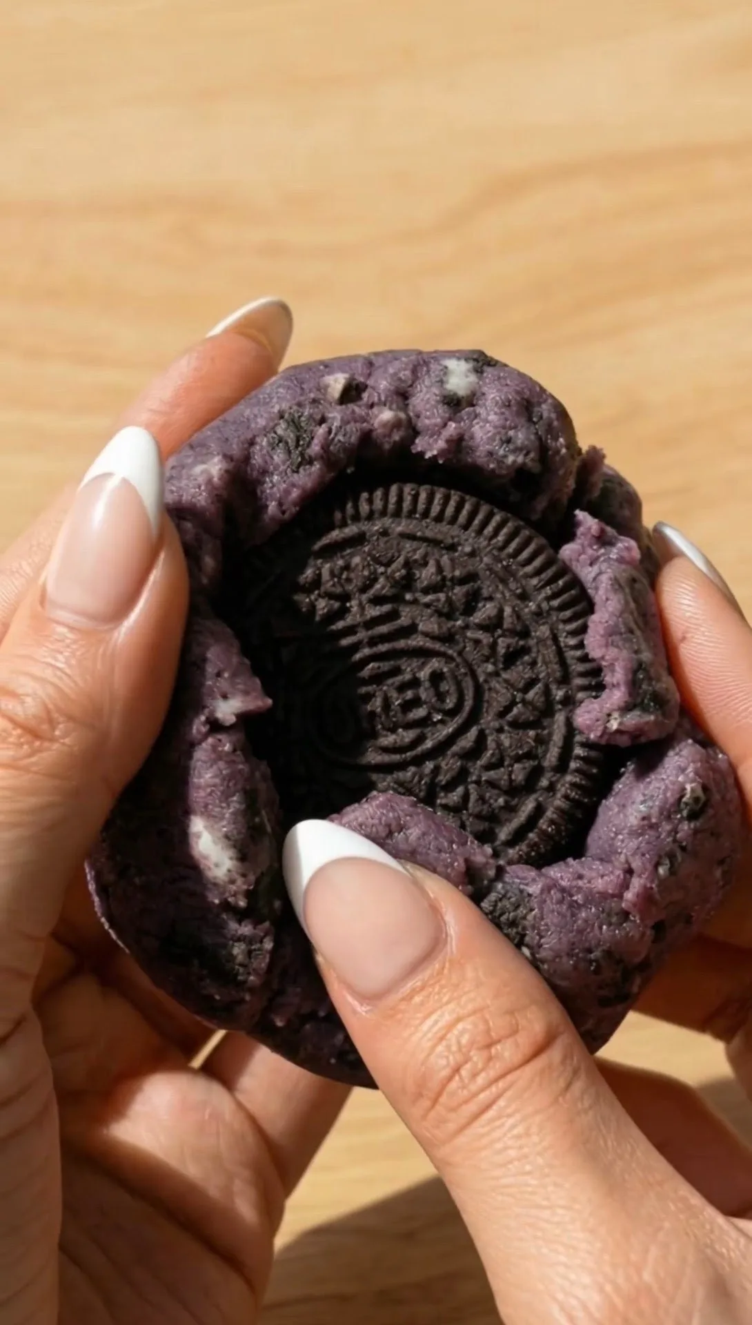 New York Style Ube Cookie aufgebrochen, der den ganzen Oreo im lila Teig zeigt