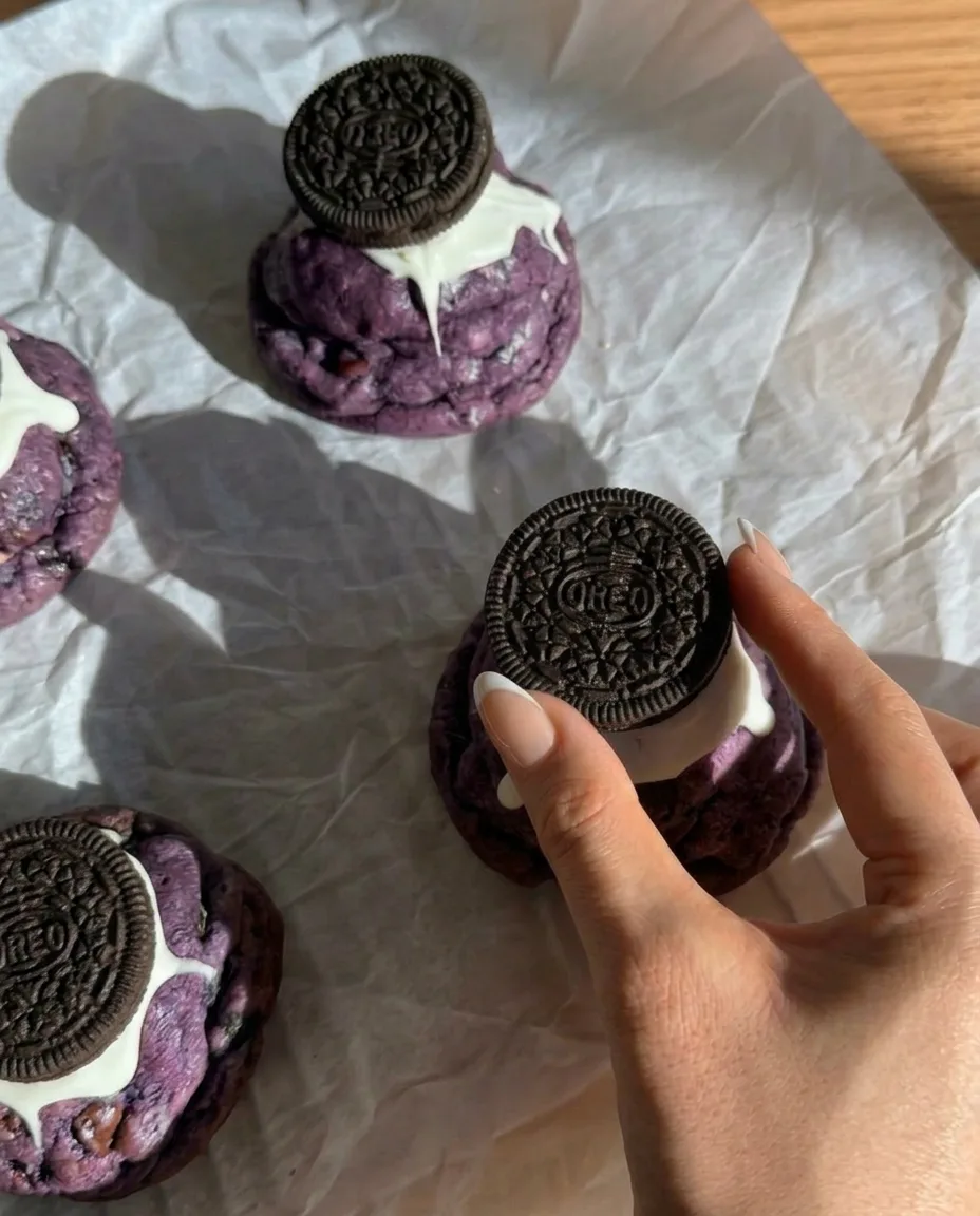 Gebackene Ube Oreo Cookies im New York Style mit ganzen Oreos daraufgedrückt und tropfender weißer Schokolade