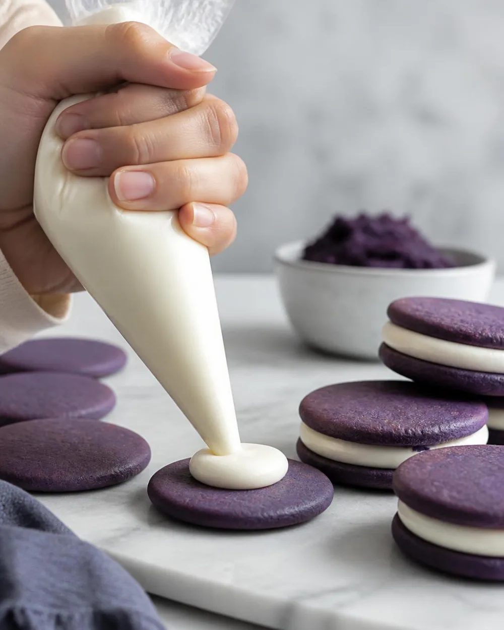 Ube Oreo Kekse füllen – weiße Schokoladen-Ganache auf lila Ube-Waffeln spritzen | Ube Nolia