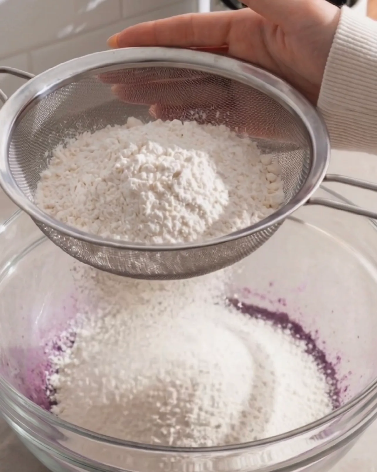 Kuchenmehl durch ein feines Sieb in den lila Ube-Teig sieben von UBE NOLIA