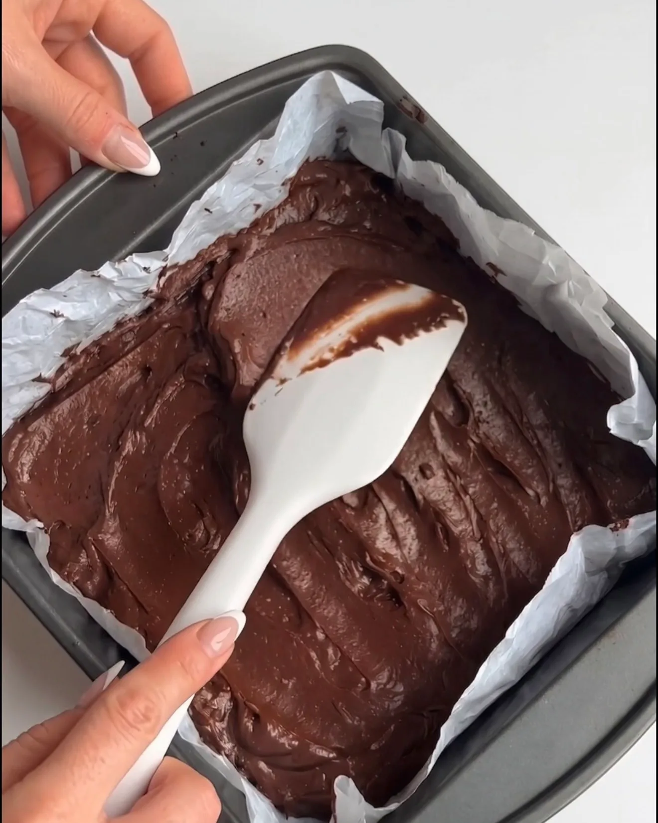 Glatter Ube Dubai Chocolate Brownie-Teig, in eine mit Backpapier ausgelegte quadratische Form gestrichen, bereit zum Backen für das Ube Nolia Rezept