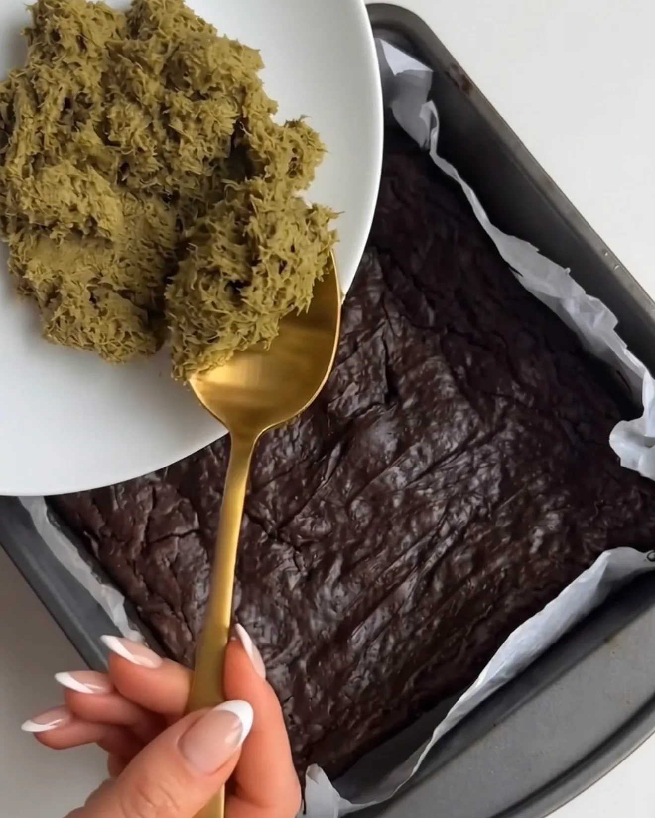 Pistazien-Kataifi-Füllung wird auf die gebackene Brownie-Basis für Ube Dubai Chocolate Brownie Riegel von Ube Nolia gelöffelt
