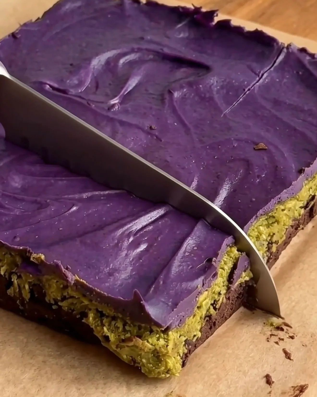 Gekühlte Ube Dubai Chocolate Brownie Riegel werden geschnitten, die Brownie-, Pistazien-Kataifi- und Ube Weiße Schokoladen-Schichten von Ube Nolia zeigend